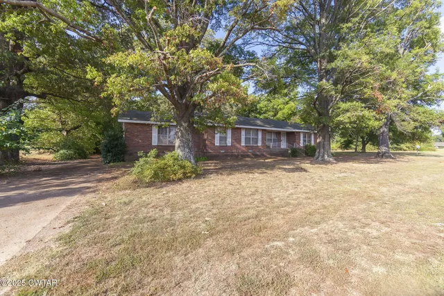 a view of a house with a yard and tree