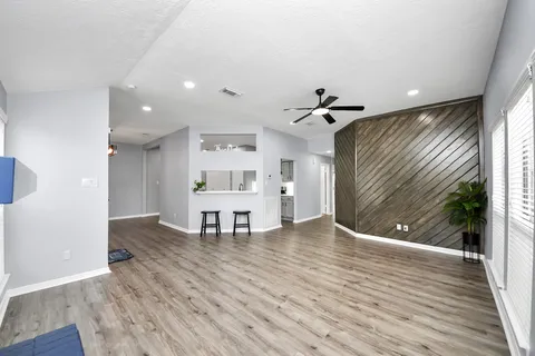 a view of a room with wooden floor and ceiling fan
