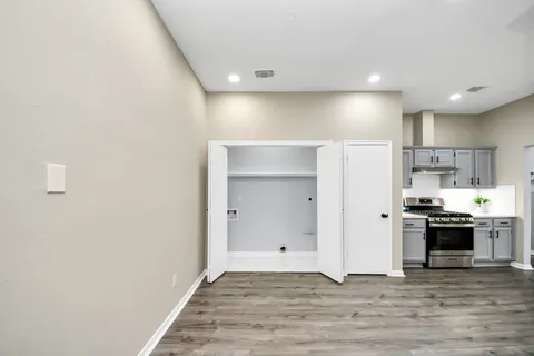 a kitchen with granite countertop a stove cabinets and wooden floor