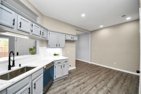 a kitchen with granite countertop a stove and a white cabinets