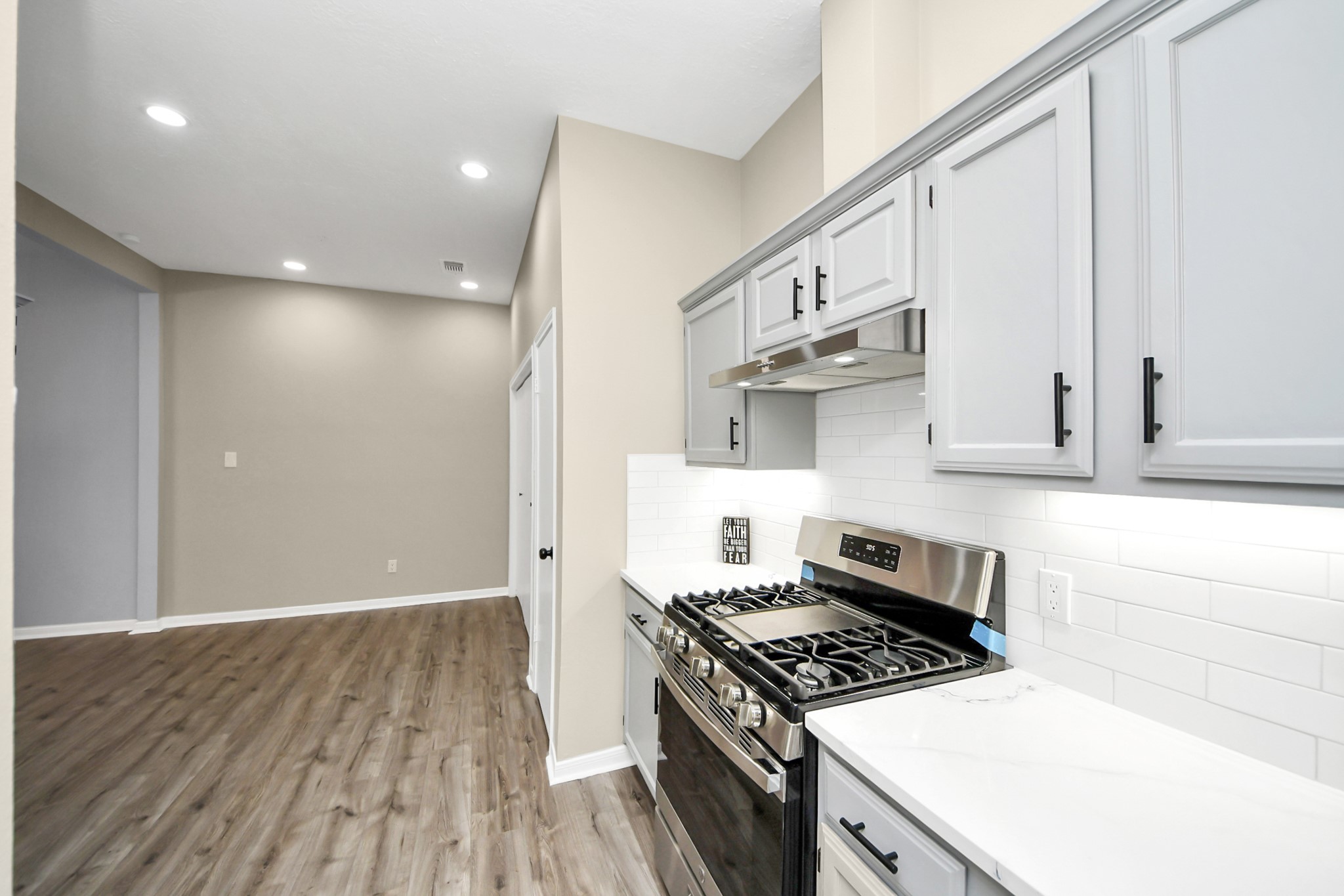 11830 Plumpoint Drive Houston, TX 77099 - Photo 26 of 40 a kitchen with granite countertop a stove and a white cabinets