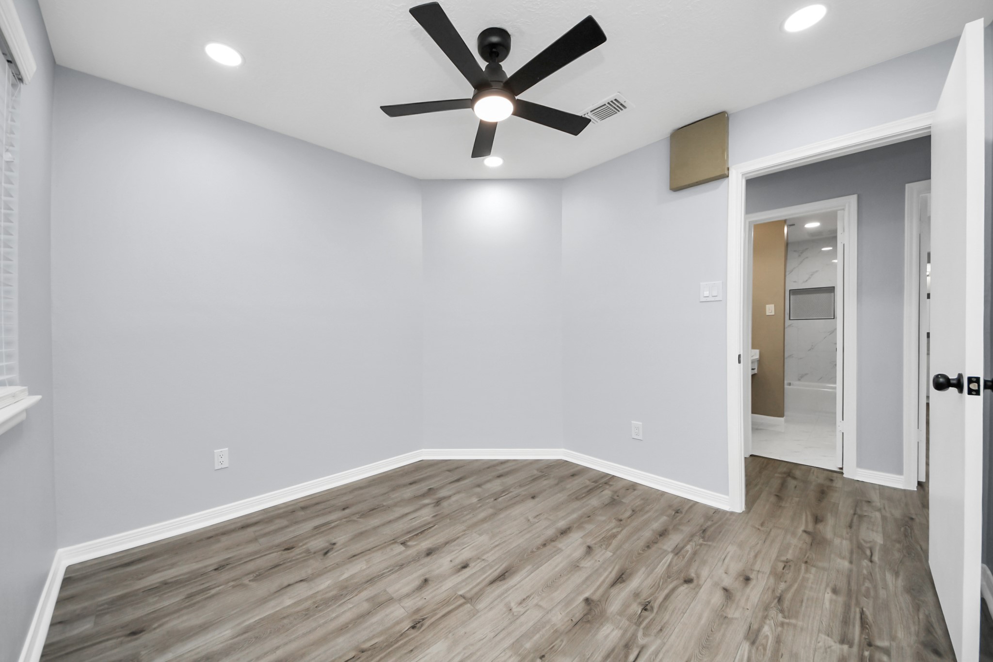 11830 Plumpoint Drive Houston, TX 77099 - Photo 37 of 40 an empty room with wooden floor and a ceiling fan