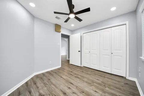 a view of a hallway with wooden floor and staircase