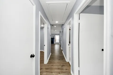 a view of hall way with furniture and wooden floor