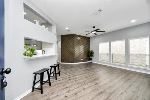 a view of an empty room with a window and wooden floor
