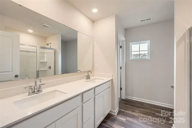a bathroom with double sink and a mirror