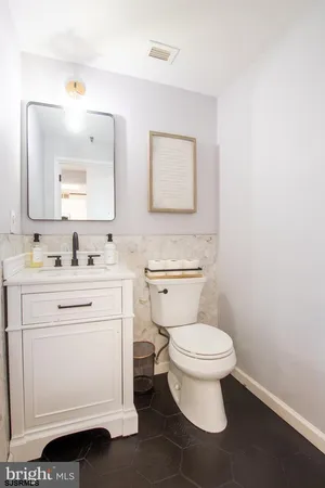 a bathroom with a toilet sink vanity and mirror