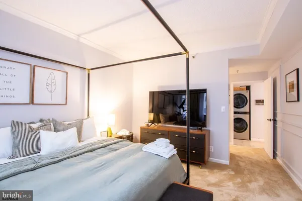 a bedroom with a bed and a flat tv screen on wall