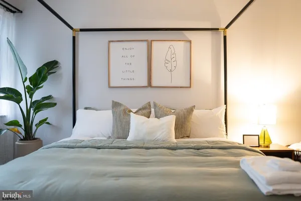 a bedroom with a bed and a painting on the wall
