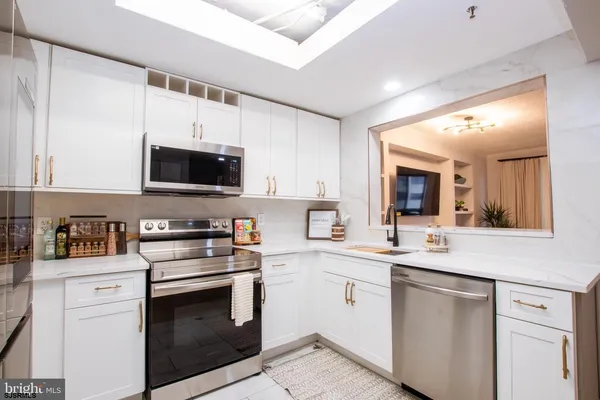 a kitchen with stainless steel appliances a sink stove and microwave