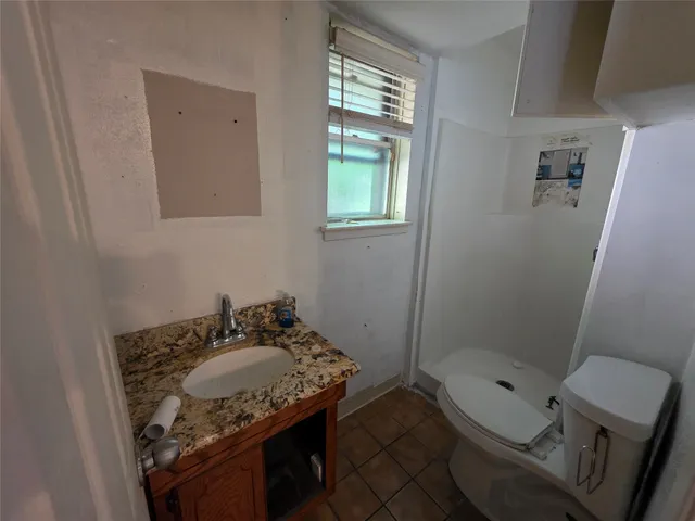 an empty room with wooden floor a ceiling fan and windows