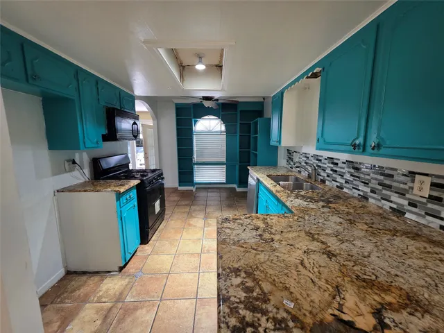 a kitchen with stainless steel appliances granite countertop a refrigerator and a stove