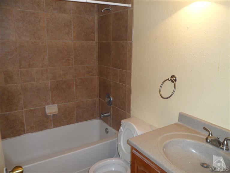 1031 Waltham Road, Unit E Simi Valley, CA 93065 - Photo 3 of 10 a bathroom with a granite countertop sink a toilet and bathtub