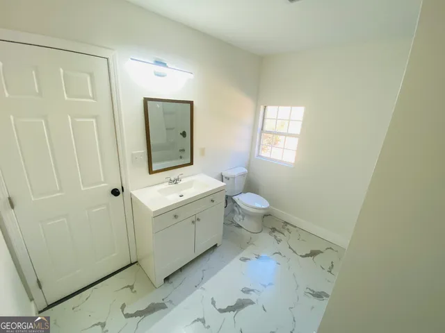 a bathroom with a sink a toilet and mirror
