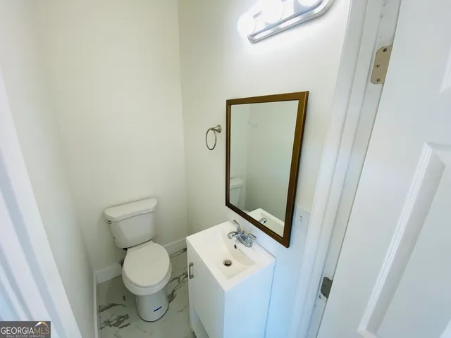 a bathroom with a toilet a sink and a mirror