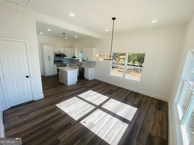 a kitchen with a white wooden cabinets and stove top oven