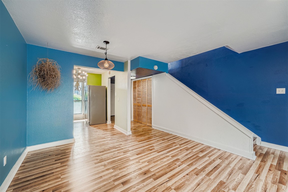 2018 West Rundberg Lane, Unit 2B Austin, TX 78758 - Photo 11 of 31 Empty room with light wood-type flooring, a textured ceiling, and a chandelier