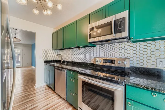 a kitchen with stainless steel appliances granite countertop a stove a microwave and cabinets