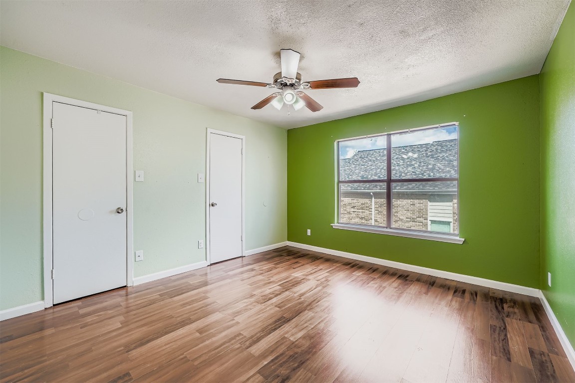 2018 West Rundberg Lane, Unit 2B Austin, TX 78758 - Photo 19 of 31 Unfurnished bedroom featuring wood finished floors, a textured ceiling, and ceiling fan