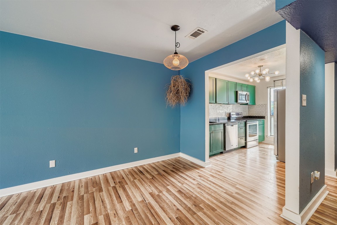 2018 West Rundberg Lane, Unit 2B Austin, TX 78758 - Photo 8 of 31 Unfurnished dining area featuring a chandelier and light wood-type flooring