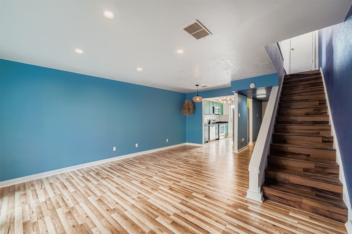 2018 West Rundberg Lane, Unit 2B Austin, TX 78758 - Photo 9 of 31 Unfurnished living room featuring stairs, light wood-type flooring, and recessed lighting
