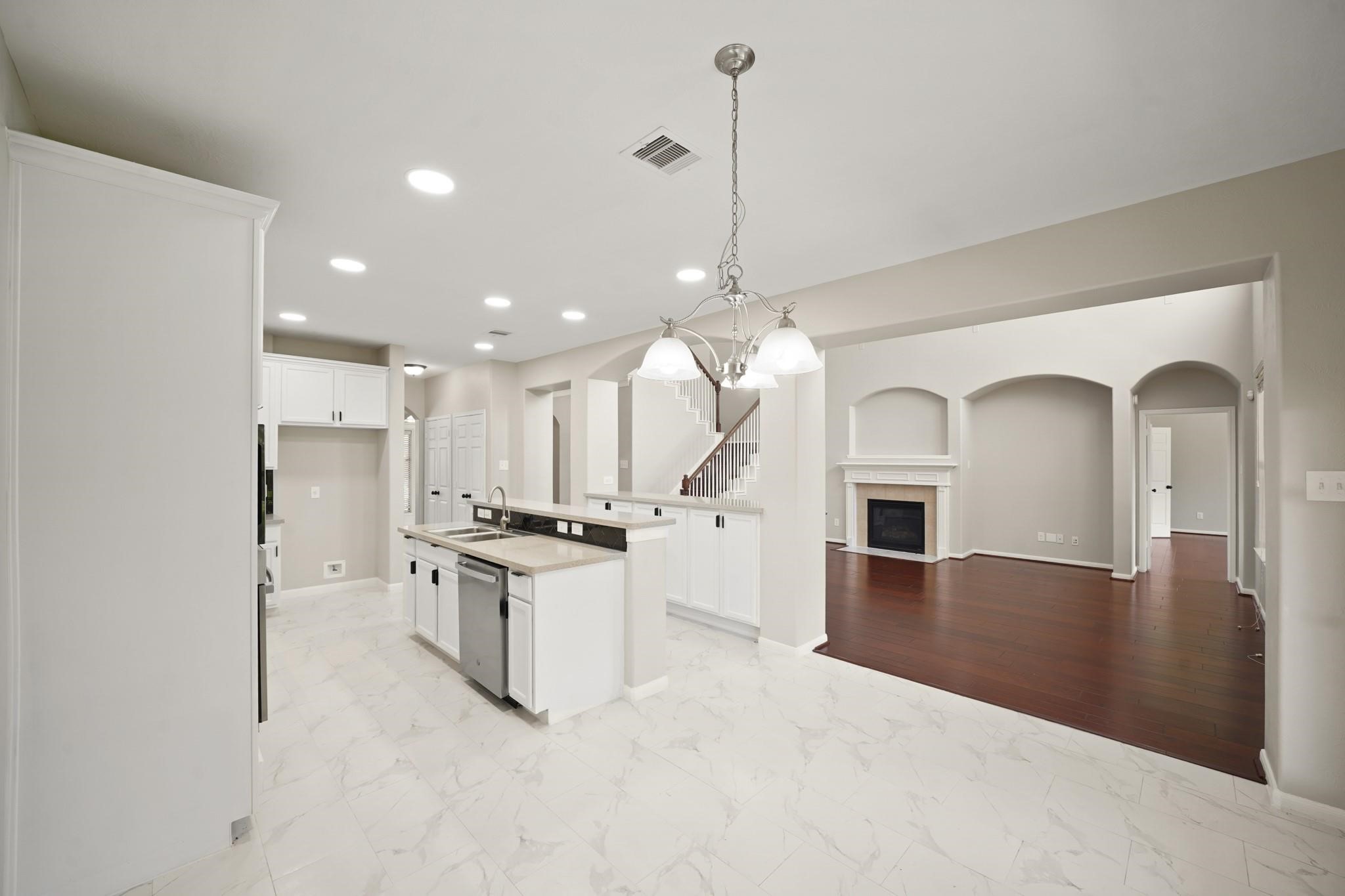 714 Coggins Point Way Sugar Land, TX 77479 - Photo 12 of 32 a view of a kitchen with a stove a refrigerator a sink dishwasher with wooden floor and cabinets