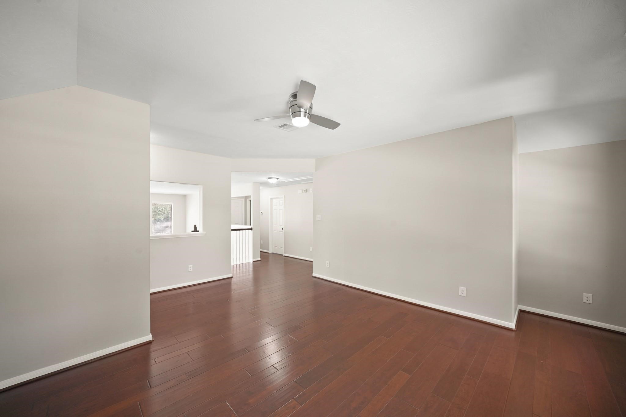 714 Coggins Point Way Sugar Land, TX 77479 - Photo 27 of 32 wooden floor in an empty room with a window