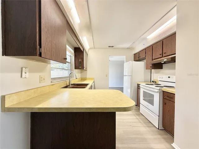 a kitchen with stainless steel appliances a stove a sink dishwasher and a refrigerator