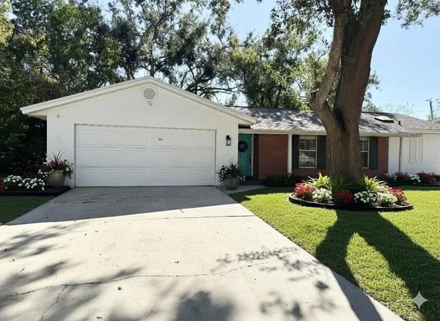 a view of a white house with yard and plants