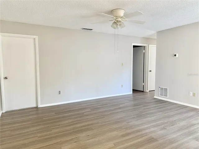 a view of an empty room with wooden floor