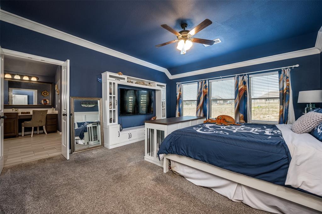 7417 Green Mesa Road Ponder, TX 76259 - Photo 19 of 39 a bedroom with a bed and a chandelier