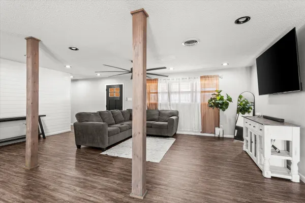 a living room with furniture a flat screen tv and a potted plant