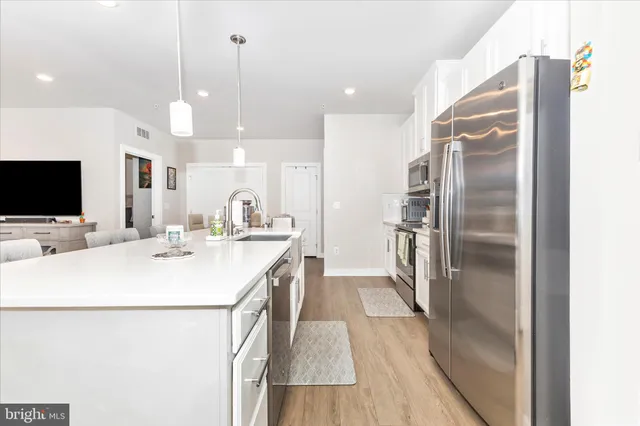 a kitchen with stainless steel appliances sink refrigerator and microwave