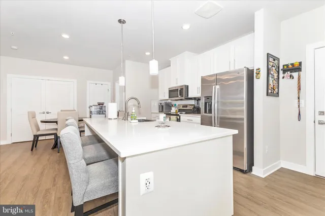 a kitchen with kitchen island a stove a table and chairs in it