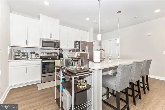 a kitchen with stainless steel appliances a sink stove and cabinets