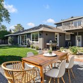 a view of a patio with table and chairs and potted plants with wooden fence