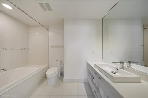 a bathroom with a double vanity sink toilet and shower