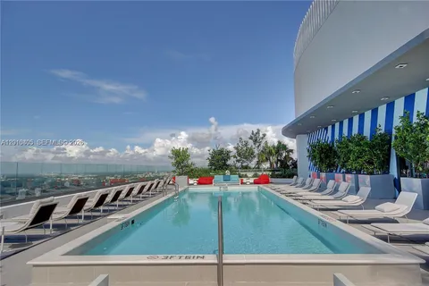 swimming pool view with plants and large tree