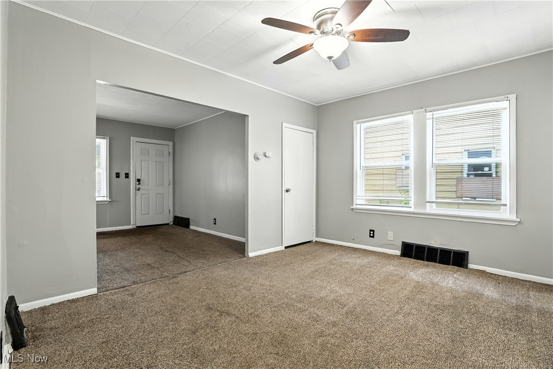 1774 Urbana Road Cleveland, OH 44112 - Photo 9 of 41 Unfurnished room featuring carpet, a ceiling fan, and ornamental molding