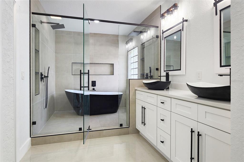 7027 Frascati Loop Wesley Chapel, FL 33544 - Photo 17 of 28 a bathroom with a sink a mirror and a shower