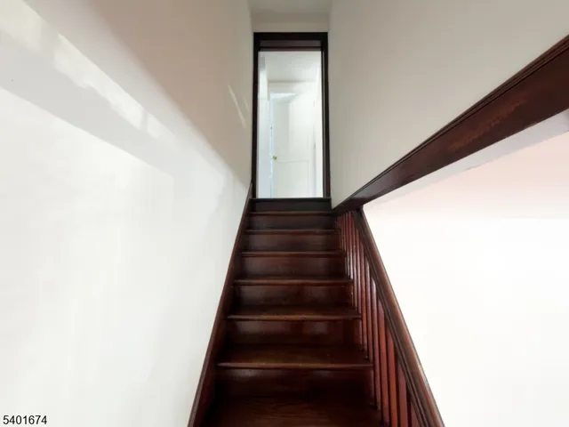 a living room with stainless steel appliances kitchen island granite countertop wooden floors and a large window