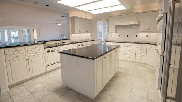 a kitchen with white cabinets appliances and a sink