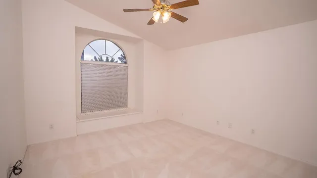 an empty room with windows and fan