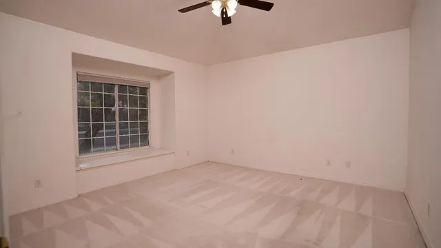 an empty room with chandelier fan