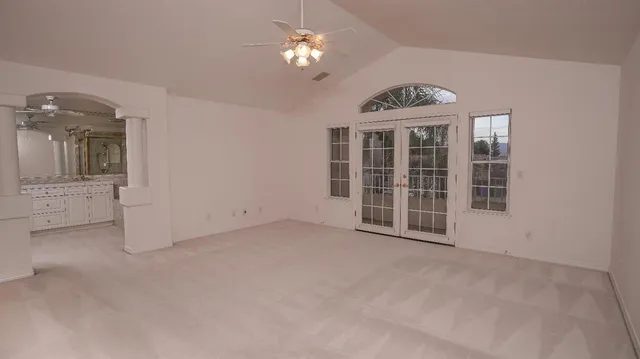 a view of a livingroom with a chandelier fan and windows