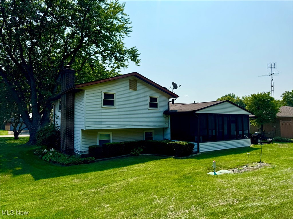 6345 Melody Road Northeast Canton, OH 44721 - Photo 4 of 8 Rear view of house featuring a sunroom and a yard