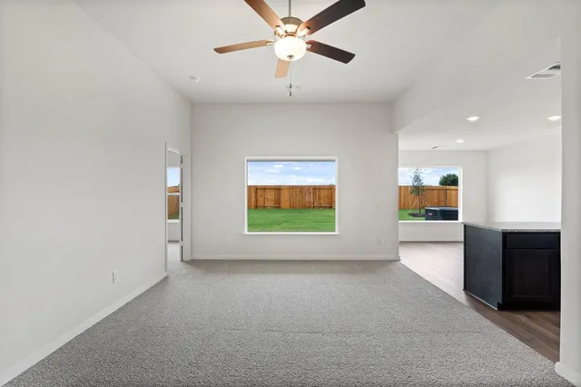 an empty room with windows and fireplace