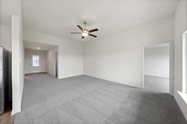 an empty room with a ceiling fan and a window