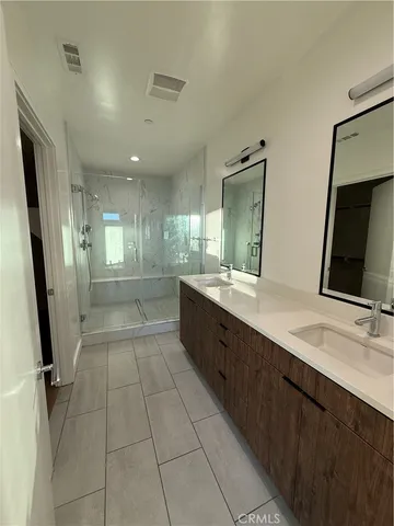 a large bathroom with a large mirror vanity and shower