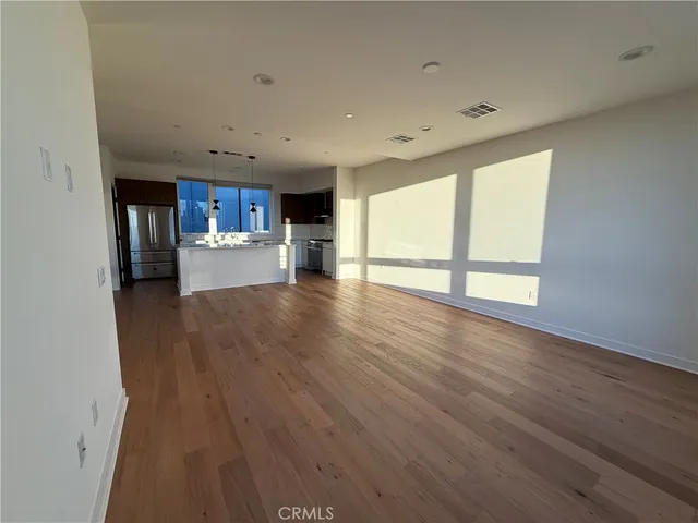 a view of empty room with wooden floor and window